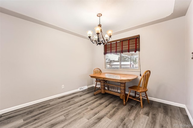 dining area with a notable chandelier, baseboards, and wood finished floors