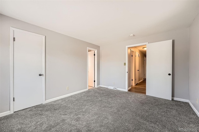 unfurnished bedroom with carpet, visible vents, and baseboards