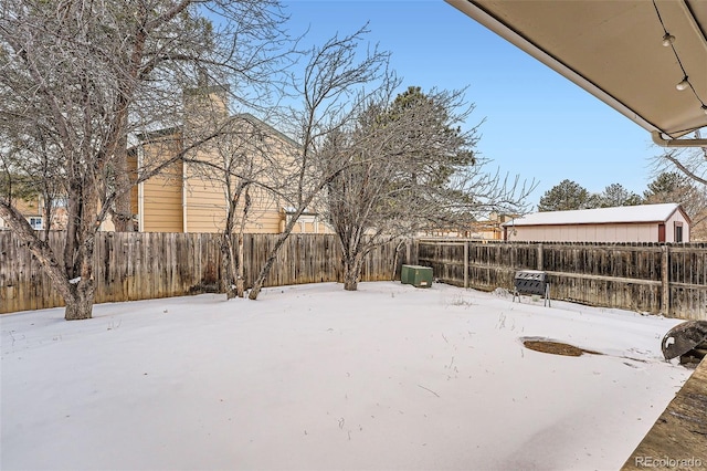 yard layered in snow with a fenced backyard