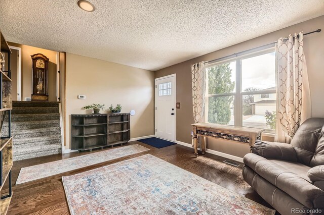 13661 W Tufts Ave, Morrison, CO 80465 - foyer featuring a textured ceiling, visible vents, dark wood-style floors, and baseboards