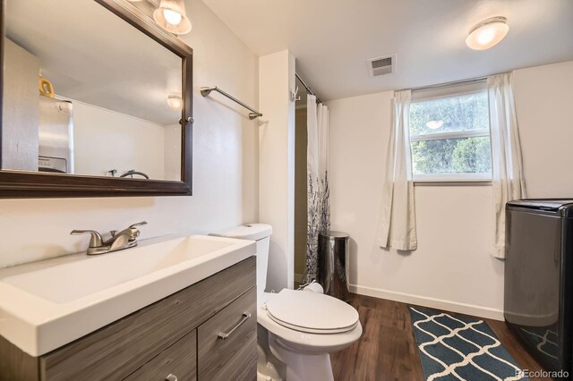13661 W Tufts Ave, Morrison, CO 80465 - full bathroom featuring visible vents, wood finished floors, baseboards, vanity, and toilet