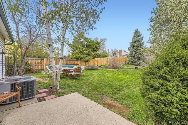 13661 W Tufts Ave, Morrison, CO 80465 - view of yard with a fenced backyard, central AC unit, a trampoline, and a patio