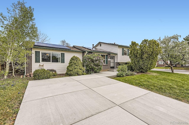 13661 W Tufts Ave, Morrison, CO 80465 - split level home with brick siding, solar panels, and a front yard