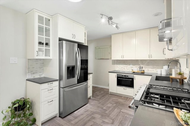 6314 Brooks Dr, Arvada, CO 80004 - kitchen featuring appliances with stainless steel finishes, a sink, decorative backsplash, and glass insert cabinets