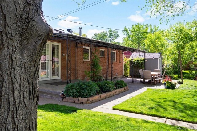 6314 Brooks Dr, Arvada, CO 80004 - view of side of property with a patio, a yard, brick siding, and french doors