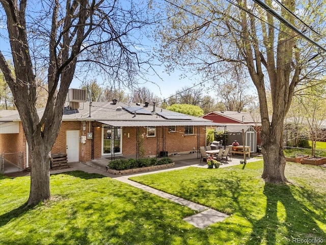 6314 Brooks Dr, Arvada, CO 80004 - rear view of property featuring brick siding, solar panels, and a patio