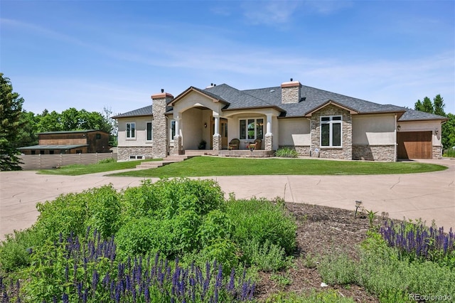 13962 W 76th Ln, Arvada, CO 80005 - view of front of house with stucco siding, stone siding, a chimney, and an attached garage