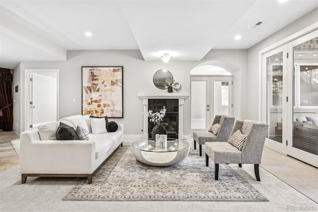 13962 W 76th Ln, Arvada, CO 80005 - living room featuring arched walkways, a tiled fireplace, recessed lighting, and carpet floors