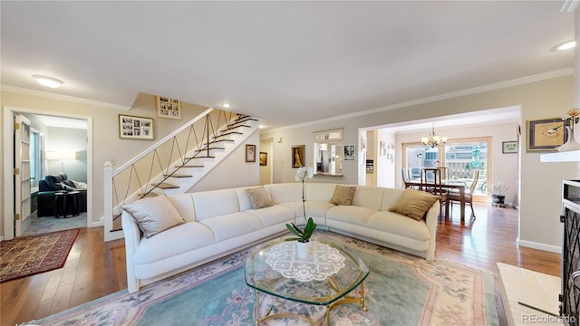 living room with crown molding, a chandelier, and wood-type flooring