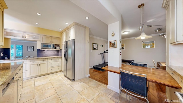 kitchen featuring pendant lighting, tasteful backsplash, ornamental molding, appliances with stainless steel finishes, and light hardwood / wood-style floors