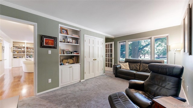 living room with light hardwood / wood-style flooring, ornamental molding, and built in features