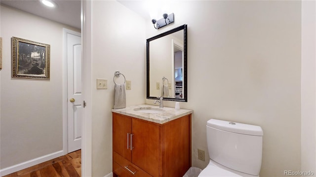 bathroom featuring toilet, hardwood / wood-style floors, and vanity