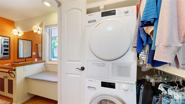 clothes washing area with stacked washer / dryer