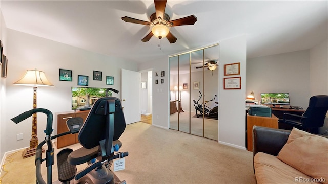 exercise area with ceiling fan and light colored carpet