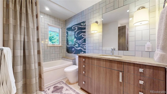 full bathroom featuring tile patterned floors, toilet, vanity, tile walls, and shower / tub combo