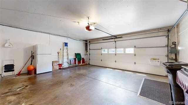 garage featuring a garage door opener and white fridge