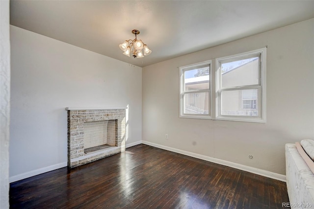 unfurnished living room featuring a notable chandelier, dark hardwood / wood-style flooring, radiator, and a brick fireplace