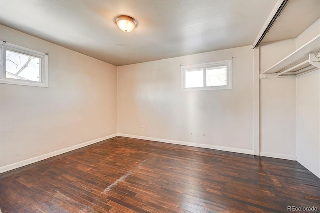 basement with dark hardwood / wood-style floors and a healthy amount of sunlight