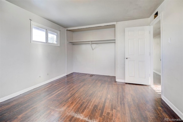 unfurnished bedroom featuring dark hardwood / wood-style floors and a closet