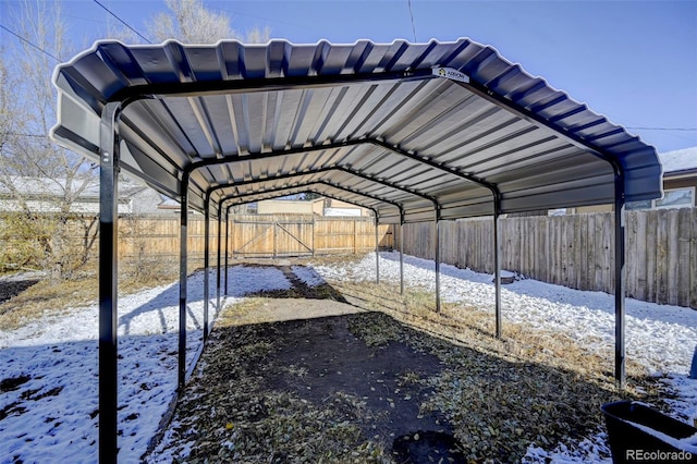 snow covered parking area featuring a carport