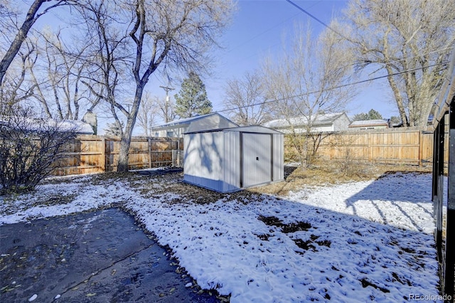 snowy yard with a storage shed