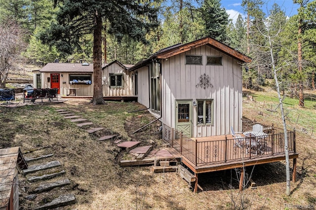 rear view of house featuring a wooden deck