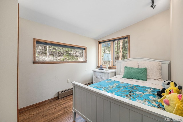 bedroom with baseboards, a baseboard heating unit, wood finished floors, and vaulted ceiling