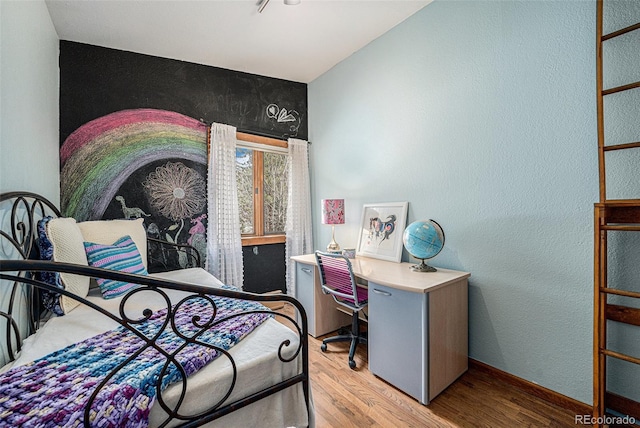 bedroom with baseboards and wood finished floors