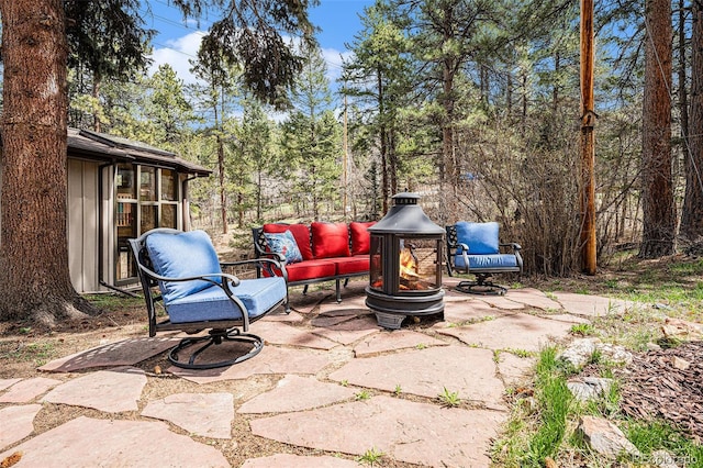 view of patio with an outdoor living space with a fire pit
