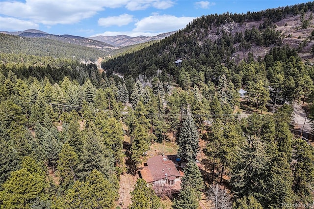 birds eye view of property featuring a view of trees and a mountain view
