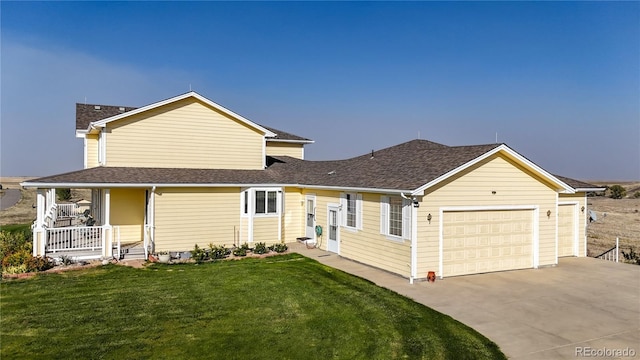 view of front of home with a front lawn, covered porch, and a garage