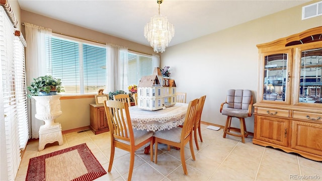 tiled dining room with an inviting chandelier