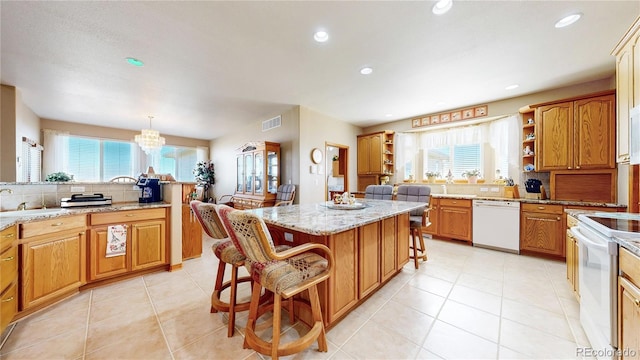 kitchen with a center island, tasteful backsplash, white appliances, hanging light fixtures, and a breakfast bar area