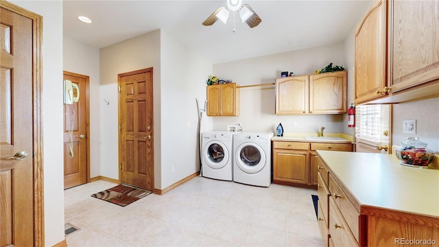 laundry area with washing machine and dryer, ceiling fan, sink, and cabinets