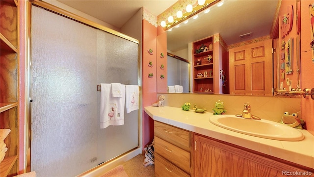 bathroom with decorative backsplash, walk in shower, and vanity