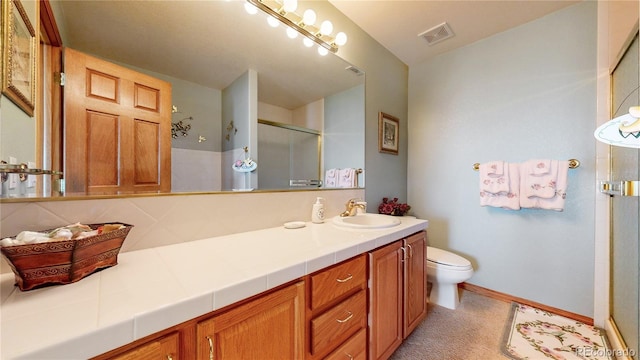 bathroom with backsplash, vanity, a shower with shower door, and toilet