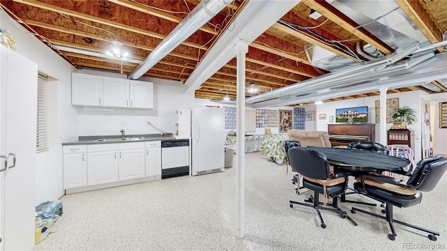 basement featuring white refrigerator and sink