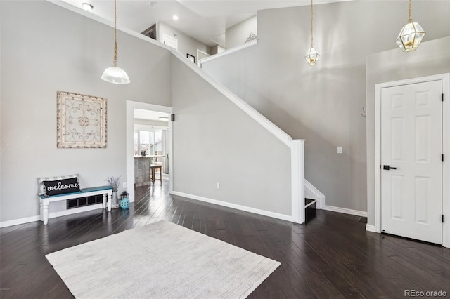 living area with recessed lighting, stairway, a high ceiling, baseboards, and dark wood-style flooring
