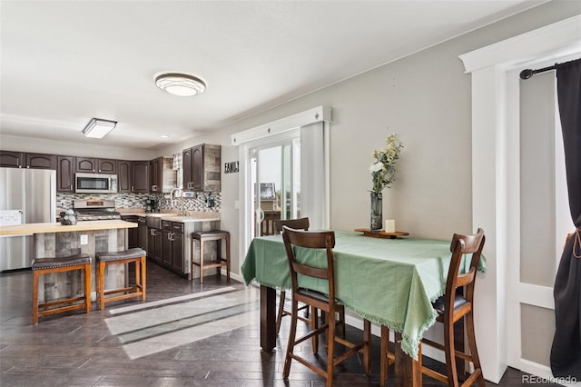 dining space featuring dark wood-style floors and baseboards