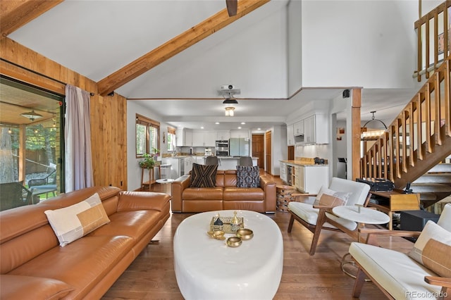 10886 E Crestline Cir, Englewood, CO 80111 - living area featuring stairs, wood finished floors, beam ceiling, high vaulted ceiling, and a chandelier