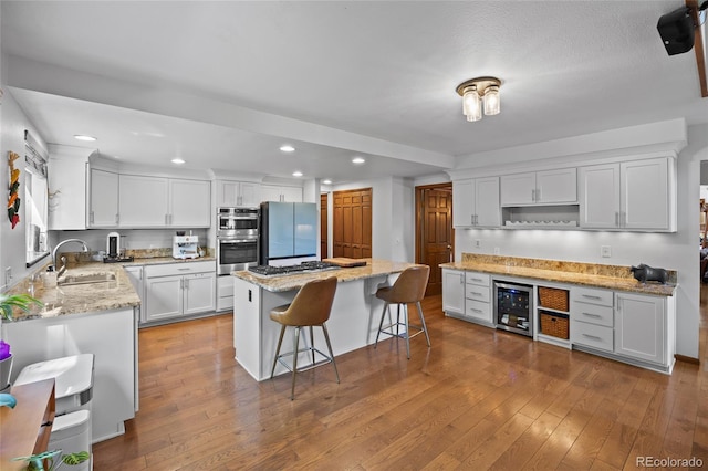 10886 E Crestline Cir, Englewood, CO 80111 - kitchen with freestanding refrigerator, wine cooler, stainless steel double oven, open shelves, and recessed lighting