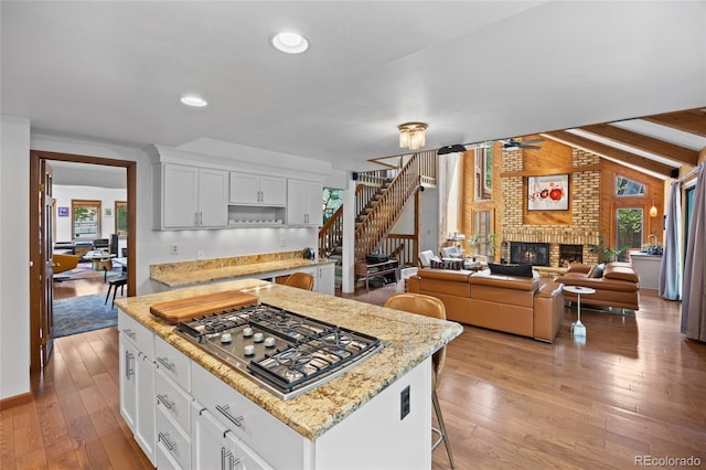 10886 E Crestline Cir, Englewood, CO 80111 - kitchen featuring stainless steel gas stovetop, plenty of natural light, light wood-type flooring, white cabinets, and recessed lighting