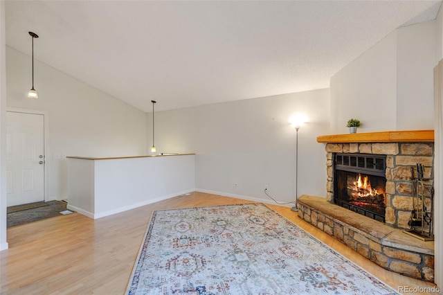 living room with a fireplace, hardwood / wood-style floors, and high vaulted ceiling