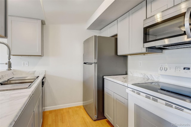 kitchen with sink, light hardwood / wood-style floors, and appliances with stainless steel finishes