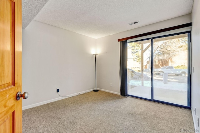 carpeted empty room featuring a textured ceiling