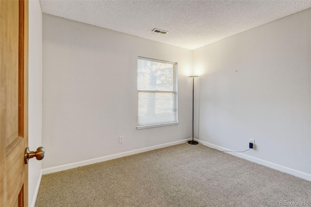 unfurnished room featuring carpet and a textured ceiling