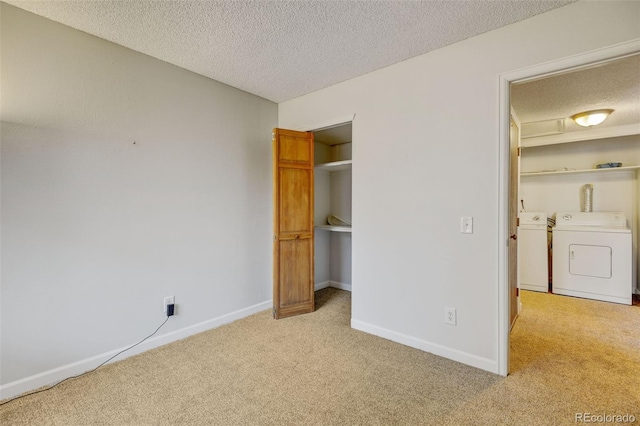 unfurnished bedroom featuring independent washer and dryer, a textured ceiling, and light colored carpet