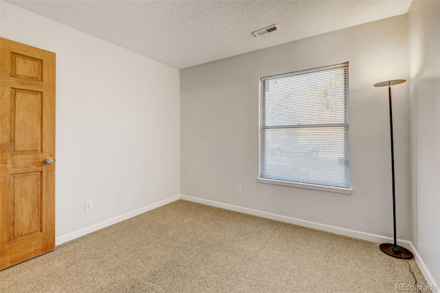 spare room featuring carpet floors and a textured ceiling