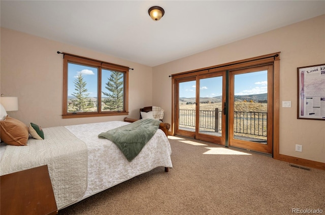 bedroom featuring a mountain view, access to exterior, and carpet flooring