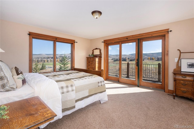 carpeted bedroom with a mountain view, access to outside, and multiple windows